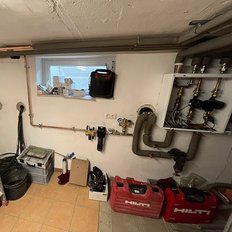 Ein gut organisierter Keller mit Rohren, Werkzeugen und einem Fenster, das Tageslicht hereinlässt.