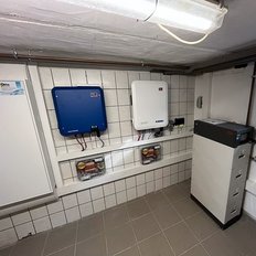 In einem modernen Technikraum sind zwei Wechselrichter an der Wand montiert, um Solarenergie zu verwalten.
