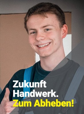 Ein junger Handwerker lächelt freundlich und zeigt mit Daumen nach oben, während er in einem hellen Raum steht.